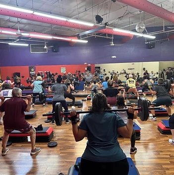 Members in a packed Body Pump barbell class