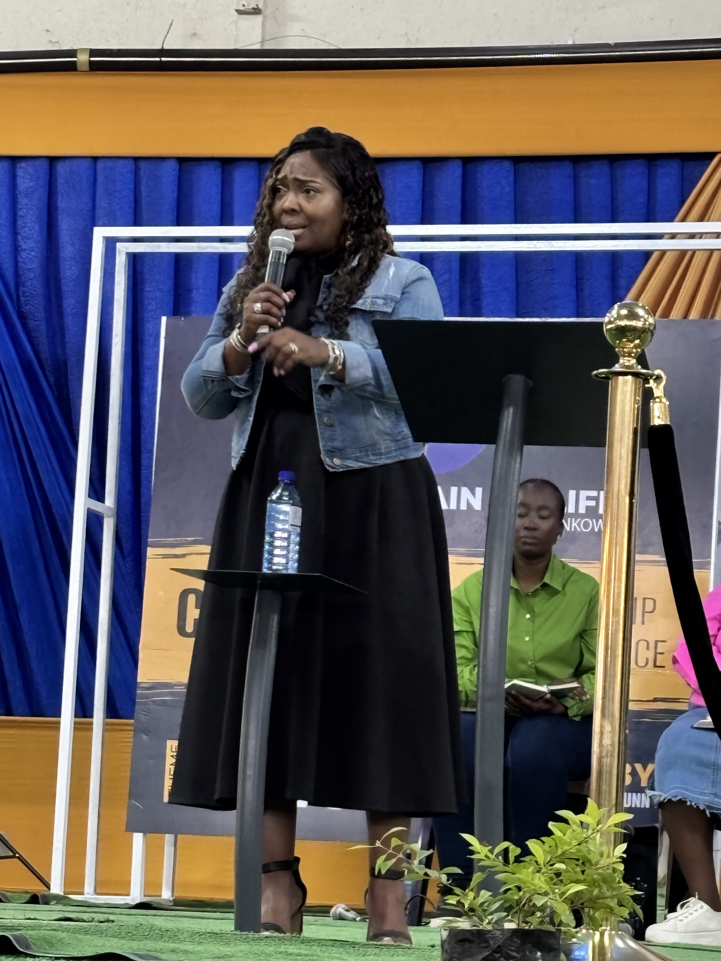 Woman speaking into a microphone on stage