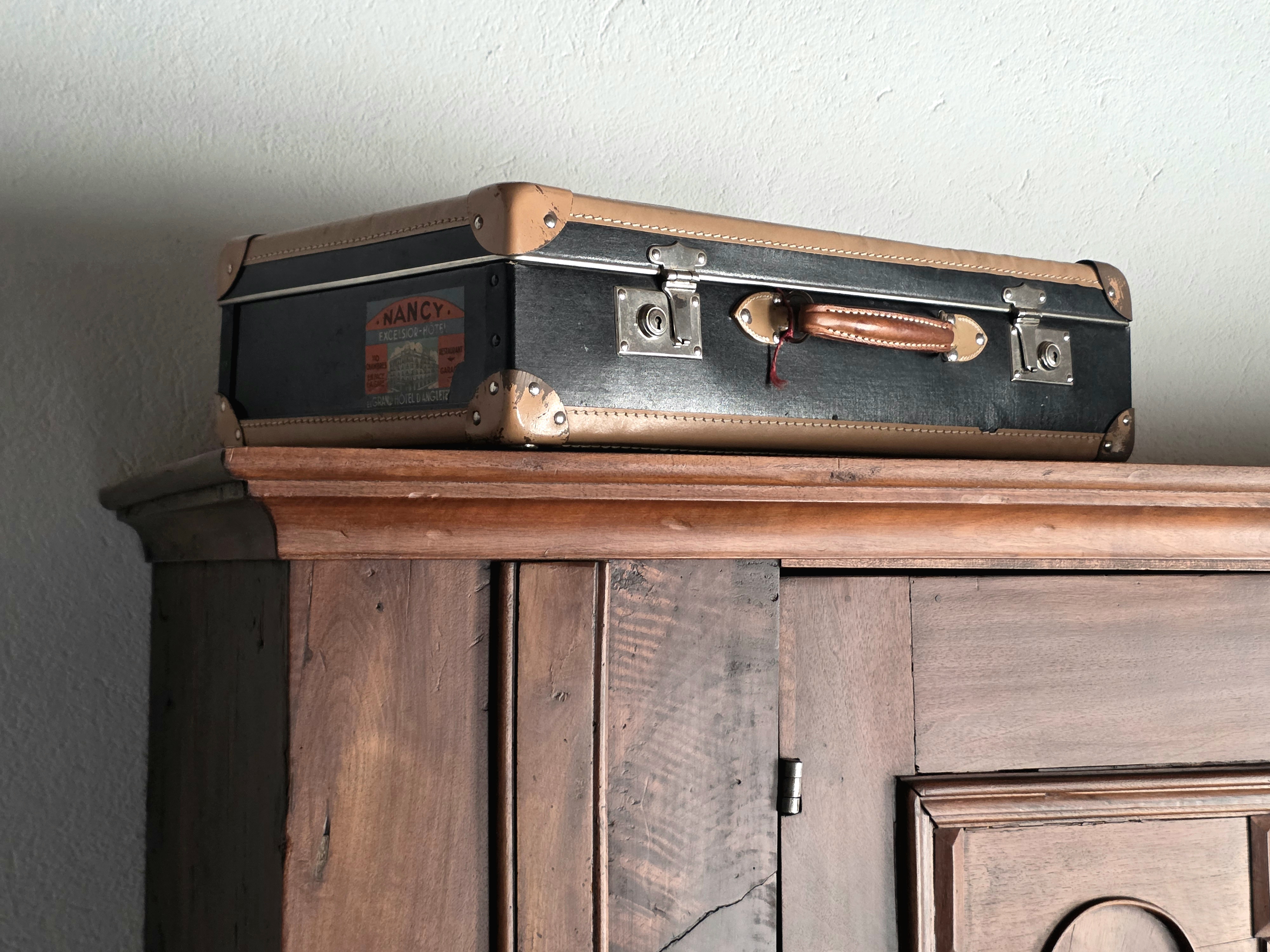 Vintage suitcase on antique wardrobe
