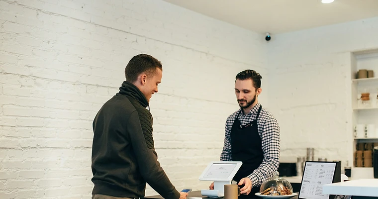 Customer chatting with the owner at a small shop counter