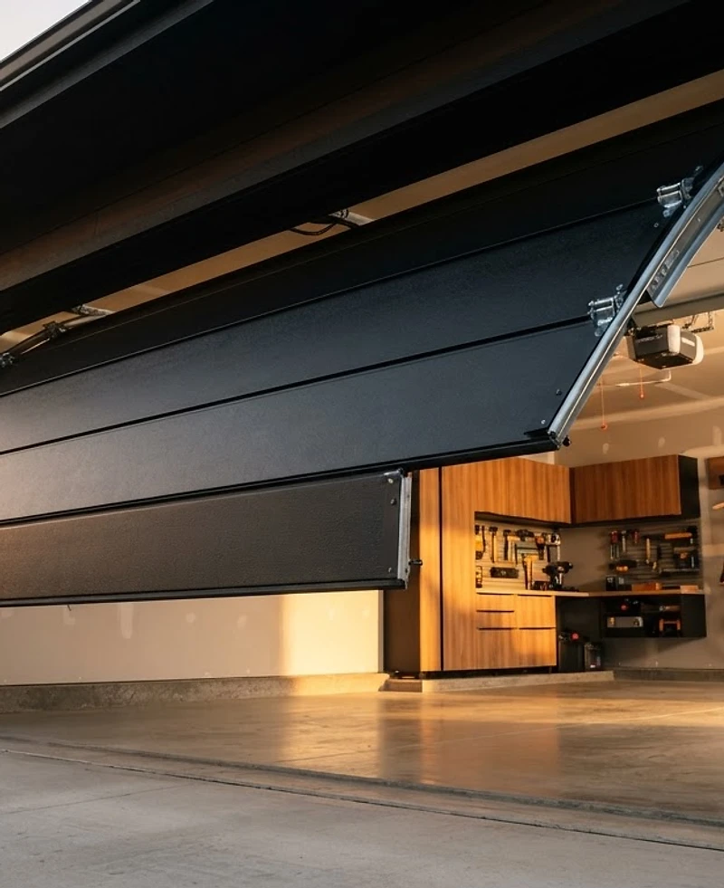 Modern matte black garage door opening to a clean suburban garage in Center Point, AL