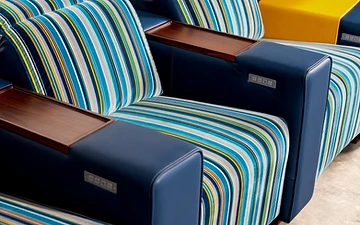 Muse armrest detail — striped textile, leather panel and timber tray