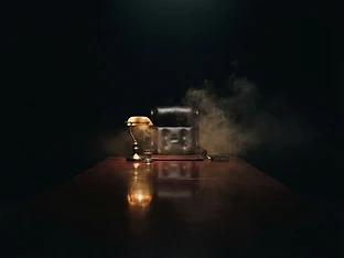 An empty chair at the head of a dark conference table