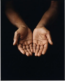 Open hands lit against darkness
