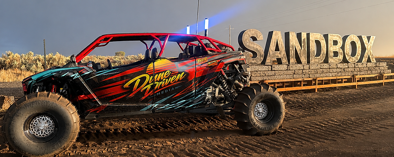 Dune Driven UTV parked at the Sandbox sign