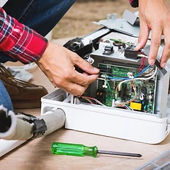 Technician connecting color-coded wiring to an HVAC control board