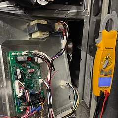 Furnace control board showing an E07 diagnostic code with a Fieldpiece meter attached