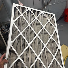Dirty, dust-clogged air filter removed before a replacement
