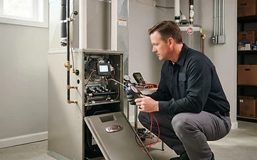 A professional technician performing a maintenance check on a residential home furnace in a clean utility room.
