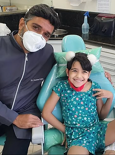 Dr. Emmanuel Caputi com paciente na cadeira odontológica