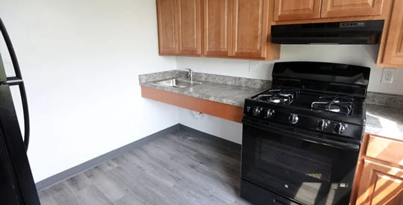 Renovated senior apartment kitchen with accessible sink and open knee clearance, Yonkers Preservation