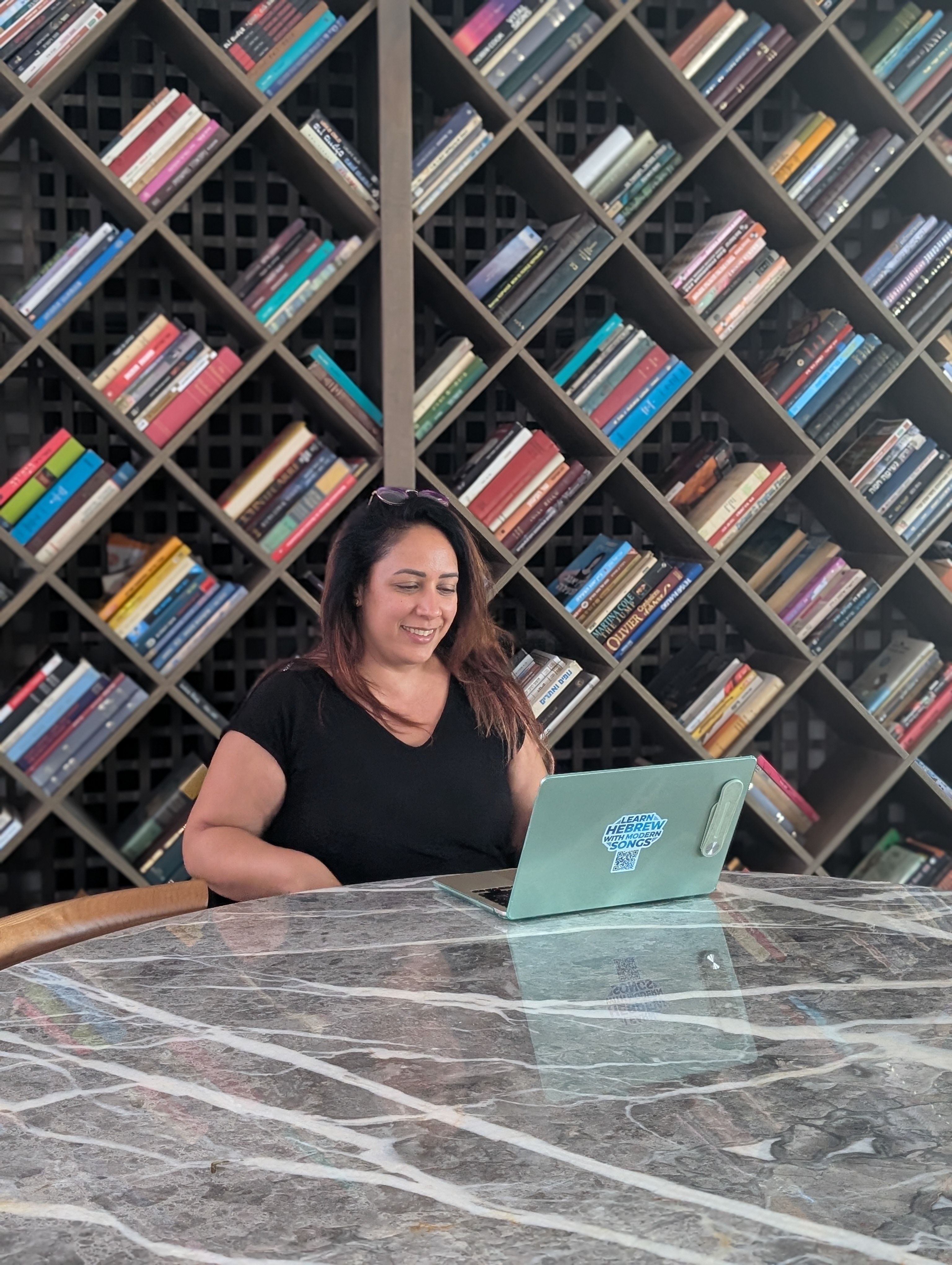 Elinor at her workspace surrounded by a library of books