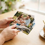 Hands holding a stack of printed photos