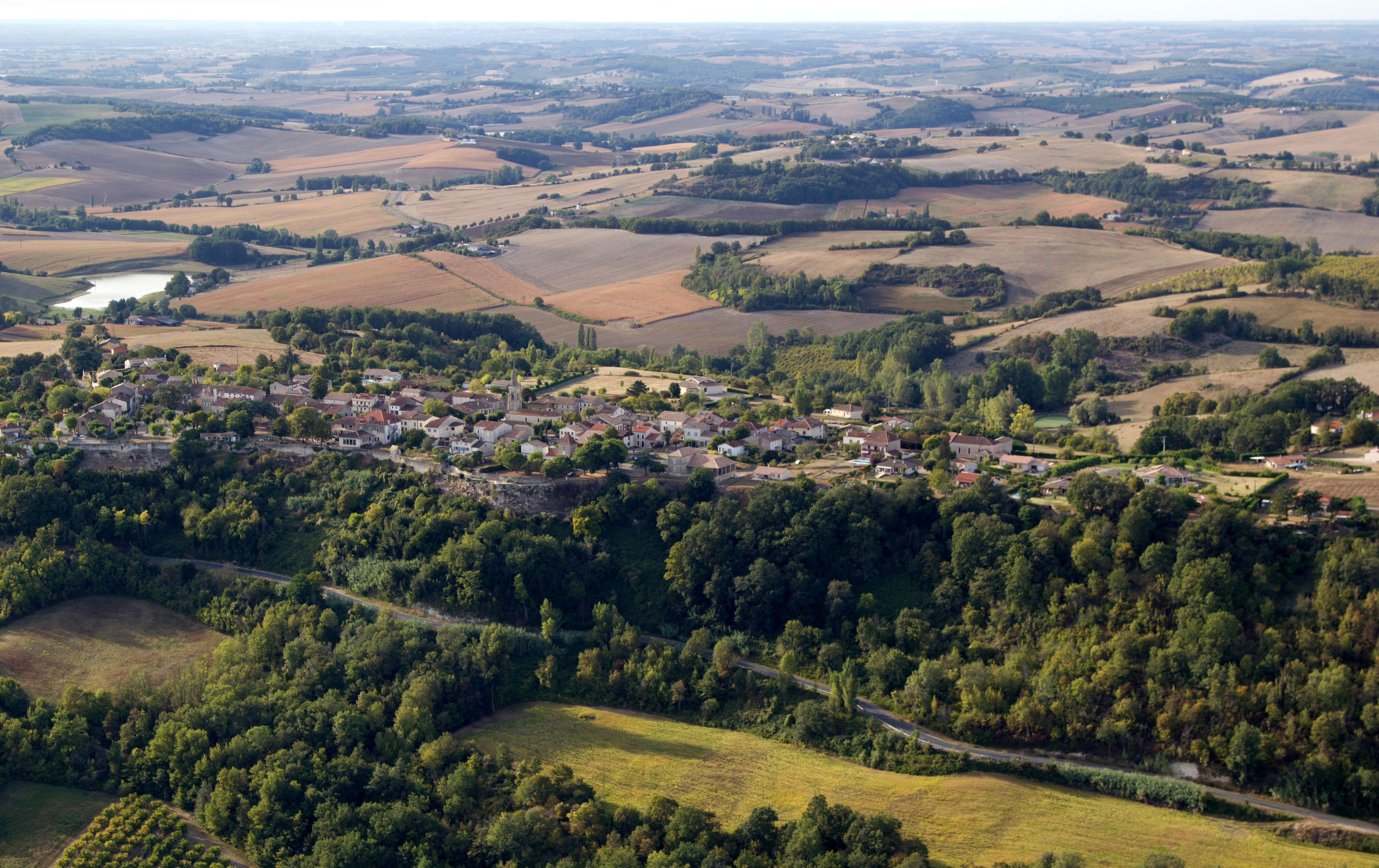 Vue aérienne d'un village et des paysages vallonnés du Lot-et-Garonne
