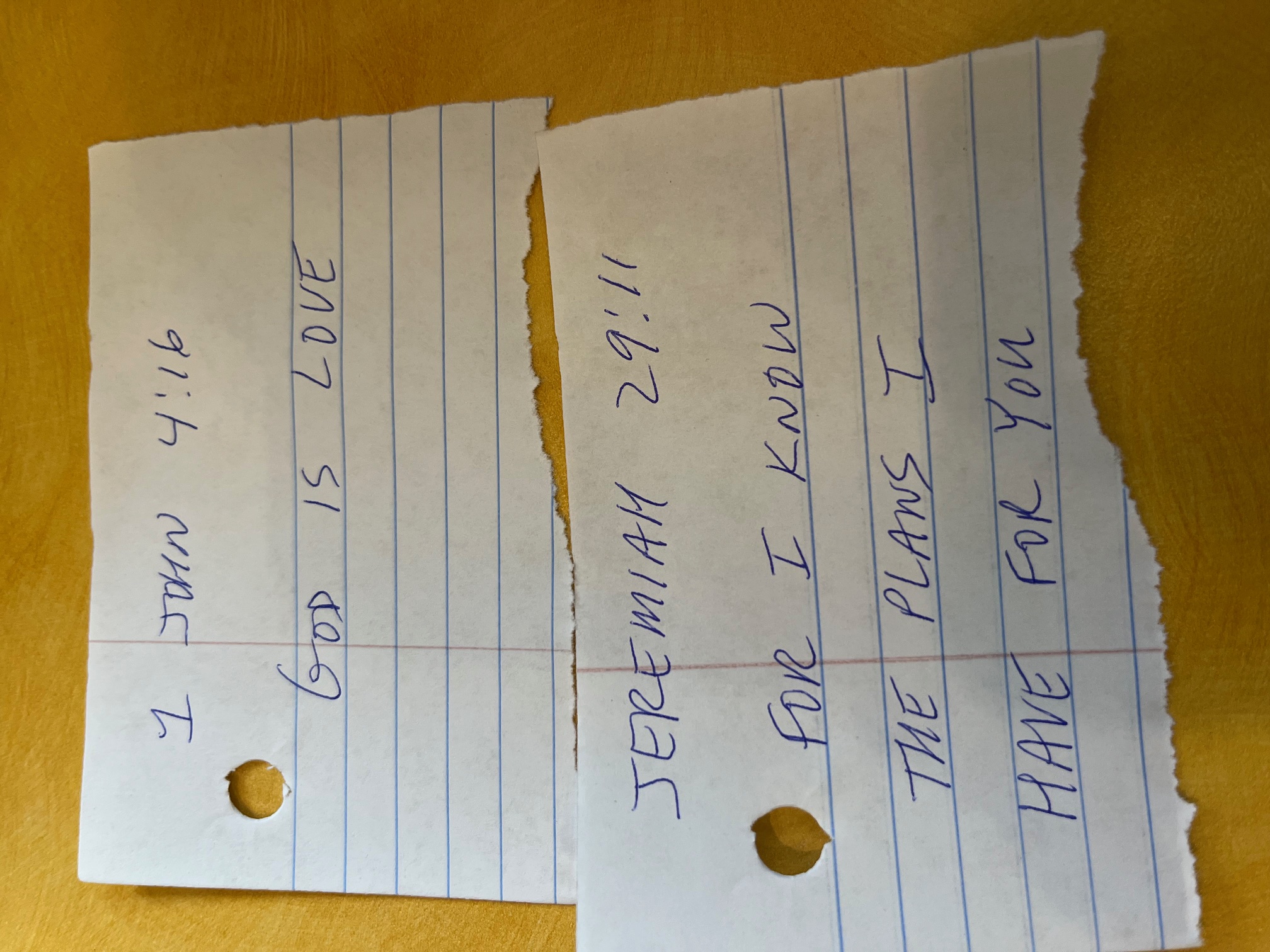 1 John 4:16 and Jeremiah 29:11 written by hand on torn notebook scraps