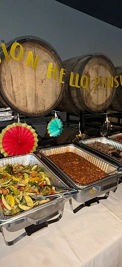 Full catering buffet spread with mac & cheese, roasted vegetables, baked beans, and smoked meats