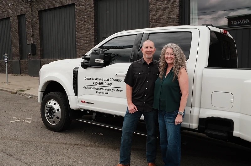 Colin and Melanie Davies with the Davies Hauling & Cleanup work truck