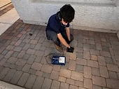 Technician performing acoustic leak detection on a residential patio