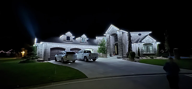Warm-white permanent exterior lighting on a luxury home