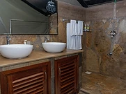 En-suite stone bathroom with twin vessel sinks at Kivuko