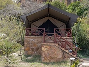 Elevated glamping tent on a stone platform at Kivuko Eco Camp