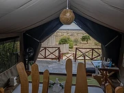 View from the bed out through the open tent flap to the savanna