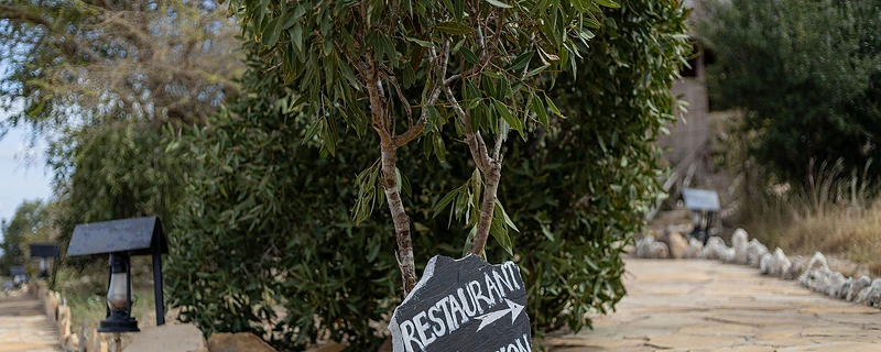 Stone signpost pointing to the restaurant and reception at Kivuko