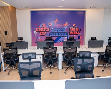 Open-plan office workspace with a colourful company values mural on the wall in Riyadh