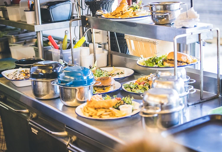 Plats prêts à être servis au passe-plats de La Buvette des Bains