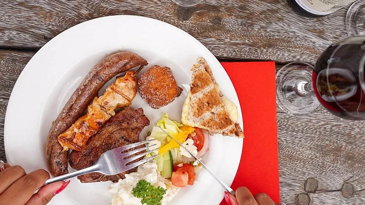 A traditional Middelvlei Boerebraai lunch plate with lamb chops, boerewors, chicken sosaties, braaibroodjies