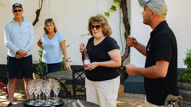 Wine in the Cape guide pouring wine for tour guests at a Stellenbosch estate