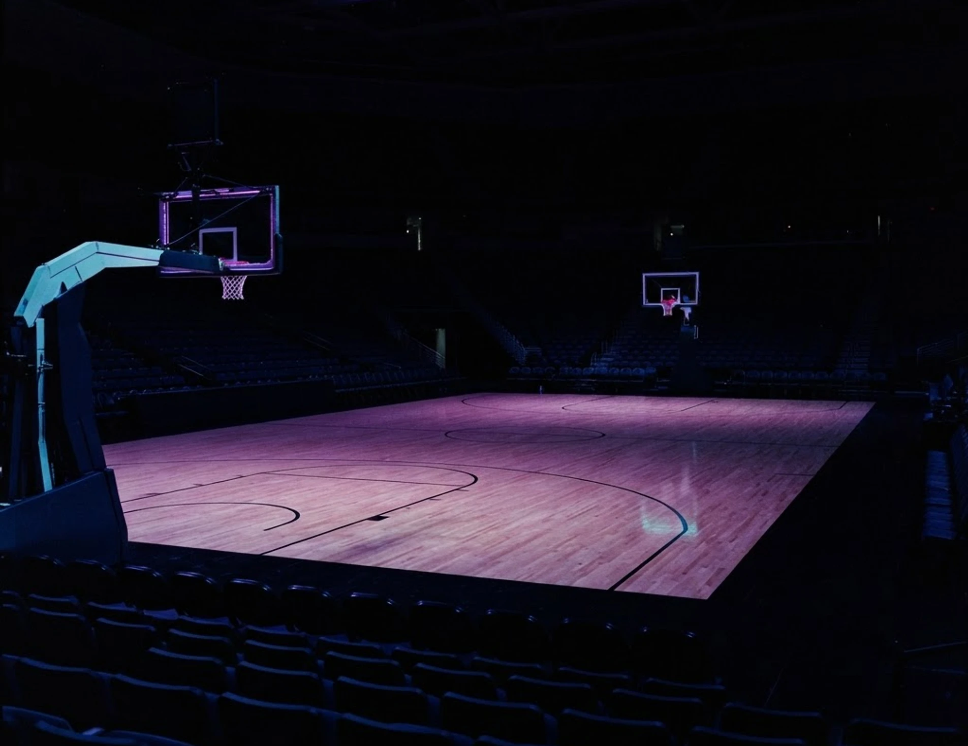 Empty indoor basketball arena at dusk