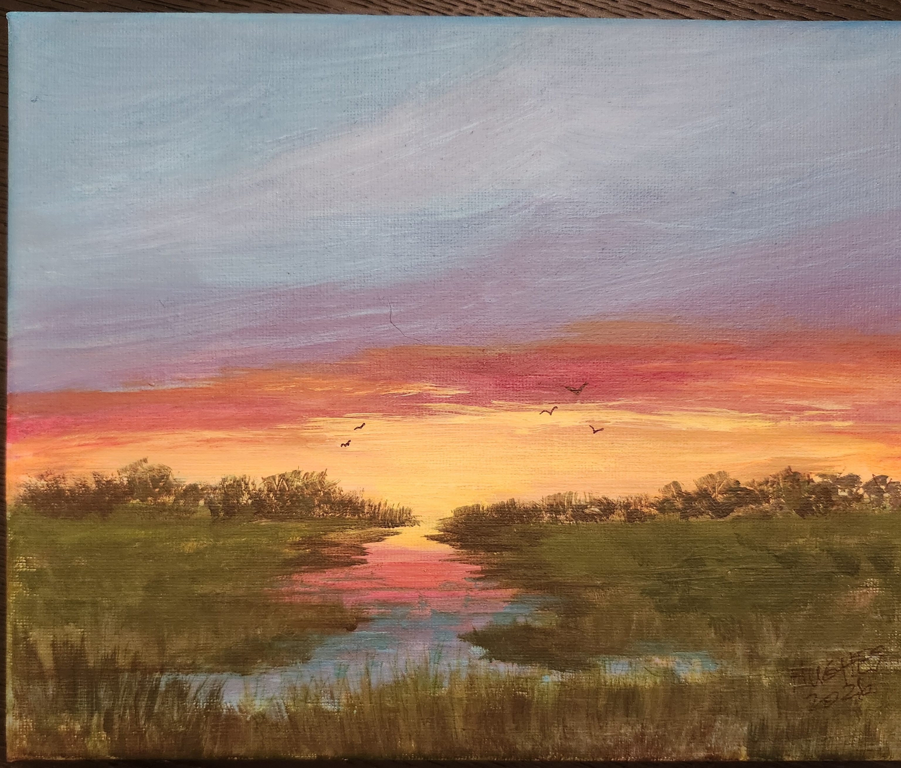 Sunset marshland painting with a vibrant magenta and orange sky, dark treeline, reflective inlet and four birds in flight.