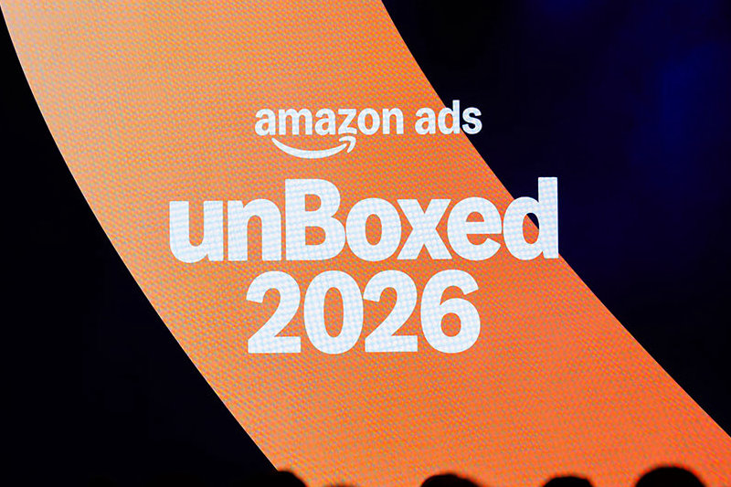 Ekran na scenie z napisem amazon ads unBoxed 2026 na pomarańczowym tle, w dole sylwetki uczestników wydarzenia.