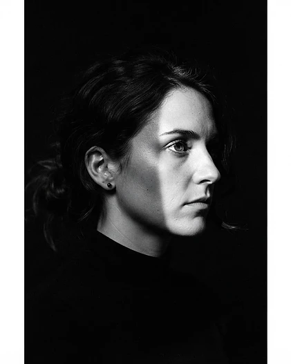 Retrato editorial de moda con sombra dura sobre muro de argamasa champagne