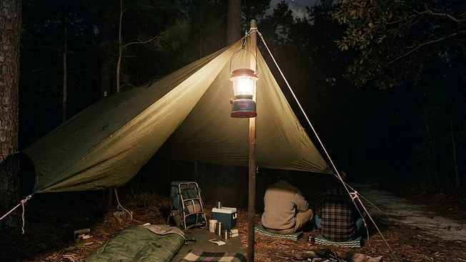 タープの下に吊るした乾電池式ランタンのキャンプの夜
