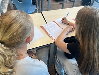 Leerling schrijft in het TOPFITKLAS werkboekje