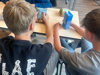 Leerlingen lezen voedingsetiketten met melk en noten