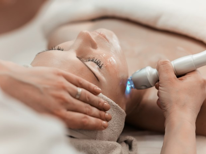 Client receiving a radio-frequency facial treatment at Pure Luminosity Spa