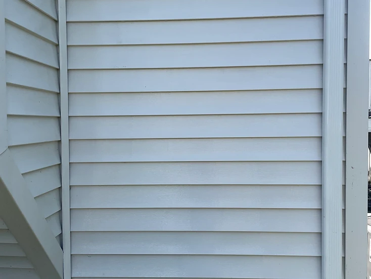 Clean white siding and window frame after a soft wash