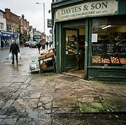 Shop entrance and paved forecourt with dirt, algae and foot-traffic grime before cleaning