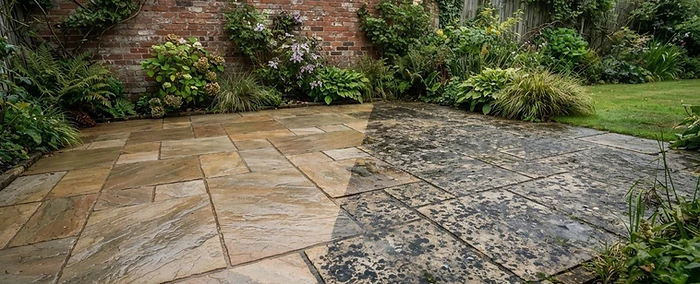 Sandstone patio half cleaned, showing black spot lichen and algae on the untreated half