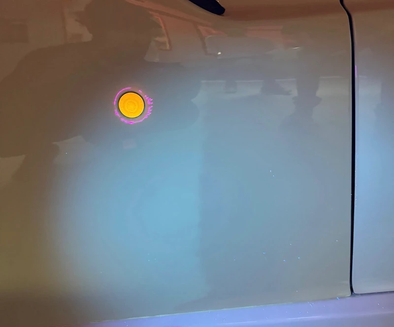 UV light reveals a hidden paint repair on a vehicle panel