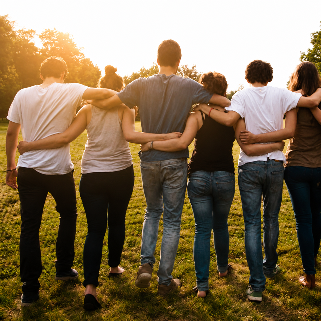 A group standing together in a field at sunset