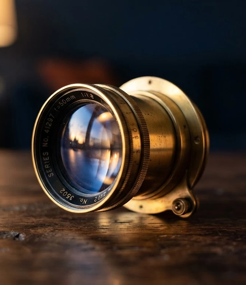 A polished vintage optical lens reflecting warm golden-hour light