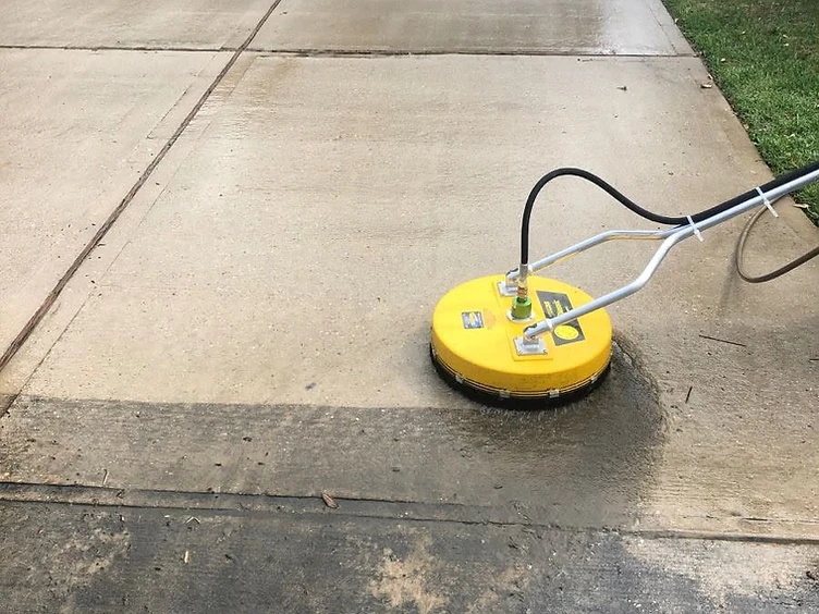 Pressure washing a stained concrete driveway with a professional surface cleaner