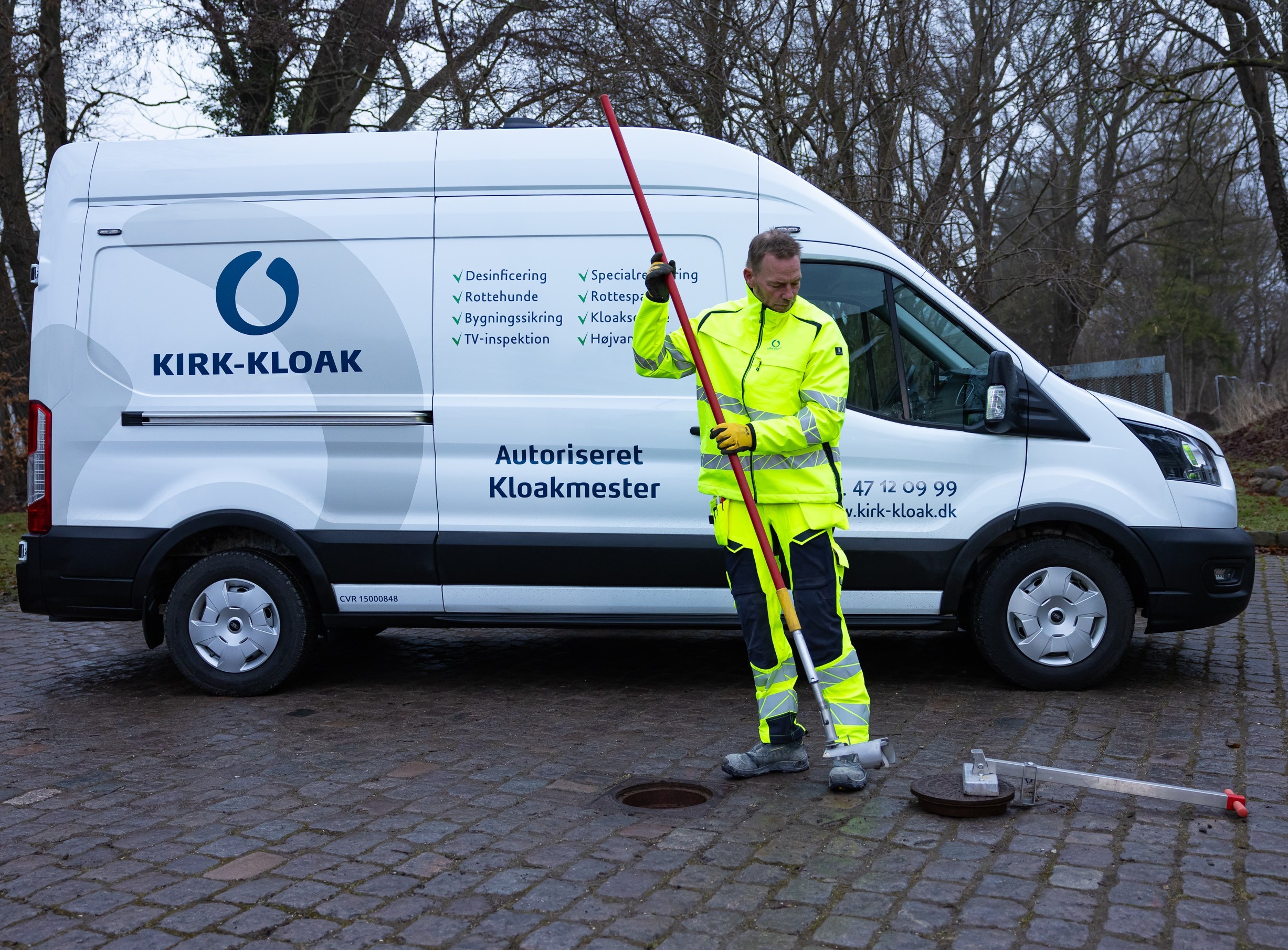 Medarbejder i gul højsynlighedstrøje på kloakarbejdsplads
