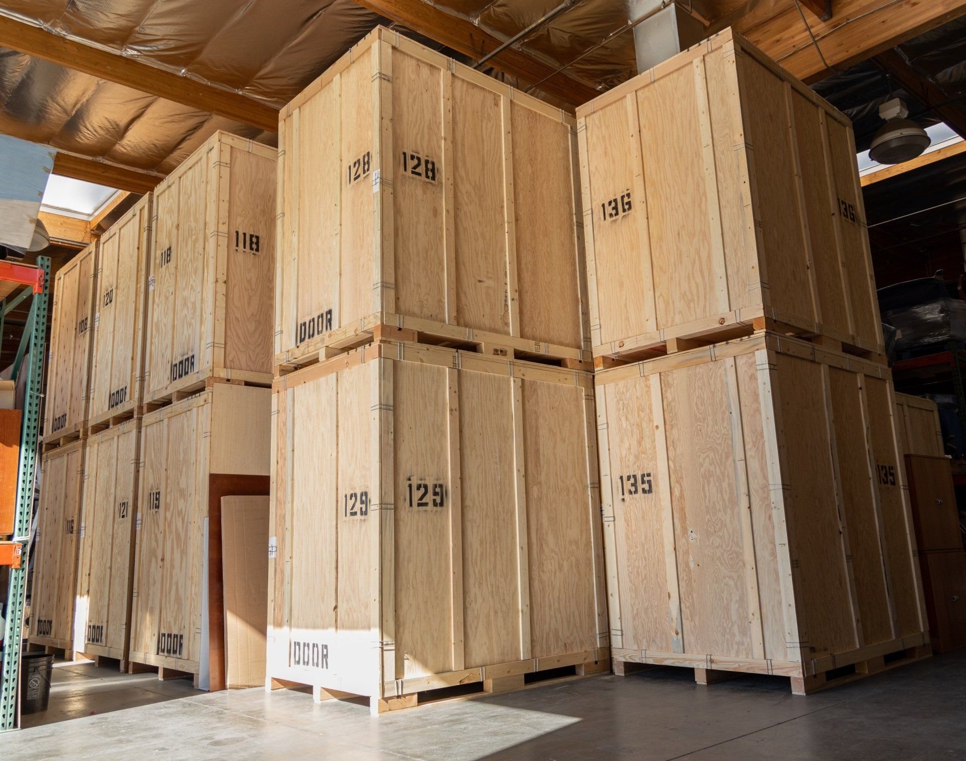 Warehouse interior with skylight illuminating stacked storage crates