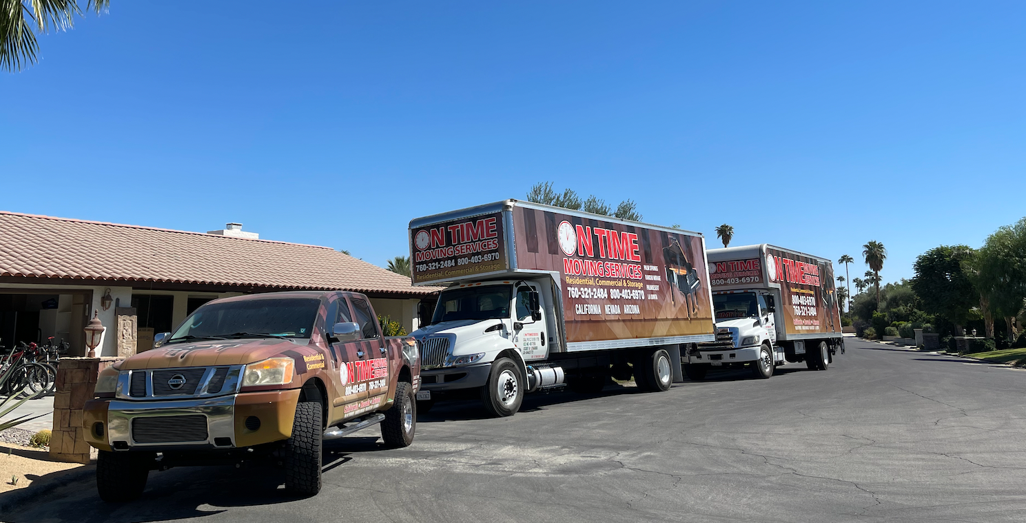Moving pickup truck and two box trucks in a neighborhood