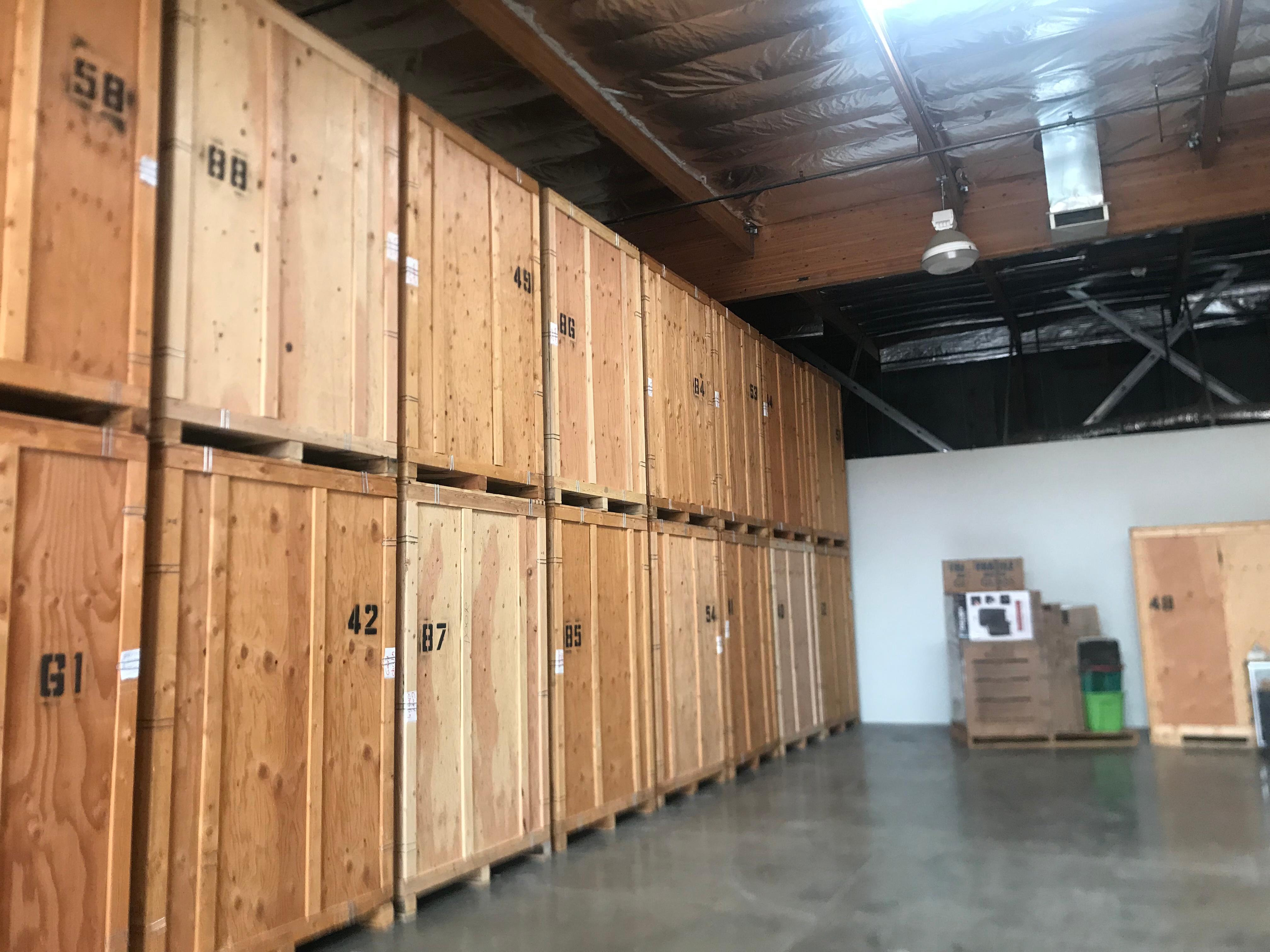 Numbered wooden storage crates stacked two-high inside a warehouse